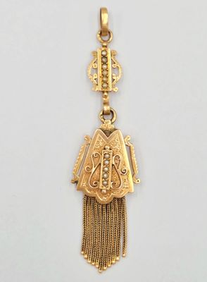 Gros plan sur un pendentif en or orné d'un oiseau