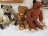 trois ours en peluche assis les uns à côté des autres sur une table