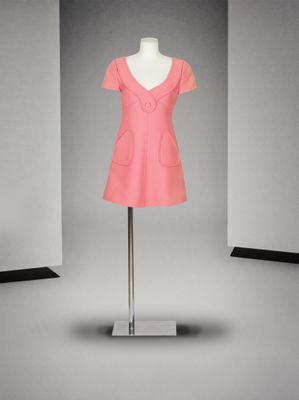 une robe rose posée sur un mannequin devant un fond gris