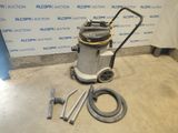 l'aspirateur est posé par terre à côté du tuyau