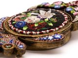 a close up of a broochee with flowers on it