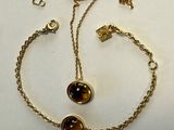 un gros plan sur un bracelet à chaîne en or orné de deux perles marron