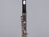 a close up of a silver and black clarinet on a clear surface
