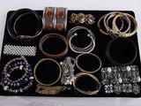 un plateau sur lequel sont disposés de nombreux types de bijoux différents