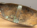 an image of a bronze sculpture of a boat on top of a wooden table