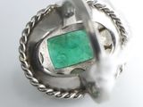 an image of a ring with a green stone inside of it