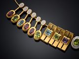 a close up of a gold necklace with various colored stones