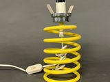 a close up of a yellow coil with a white light on it