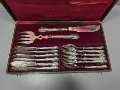 des couverts dans un coffret rouge posé sur une table recouverte d'une nappe rouge