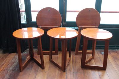 trois chaises en bois posées sur un parquet en bois dur