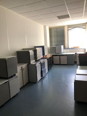 une pièce où se trouvent de nombreux bureaux et armoires