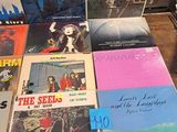a lot of records on a table with a clock in the background
