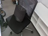 a black office chair with a black seat in a room