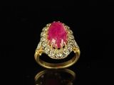 a gold ring with a pink stone surrounded by white diamonds