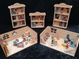 three miniature wooden dolls houses are shown on a black background
