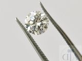 un gros plan d'un diamant tenu par une paire de pinces