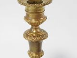 a gold colored candle holder on a white background
