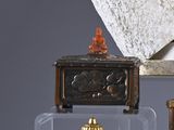 a small clock sitting on top of a table next to a vase
