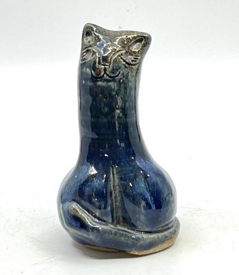 un vase bleu orné d'un chat, posé sur une table