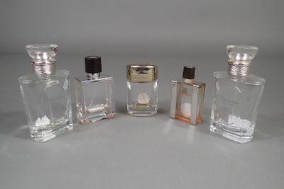 three small bottles of perfume sitting next to each other on a table