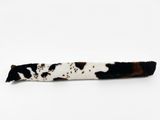 barrette aux cheveux marron et blancs, avec des taches noires sur fond blanc