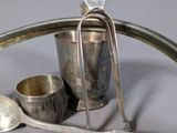 a silver tray with spoons and a cup on it