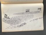 an open book with a drawing of a baseball game on it
