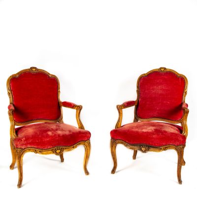 deux chaises rouges ornées de passementerie dorée et dotées d'une assise rembourrée rouge