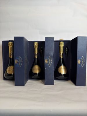 three bottles of champagne in a blue box on a table