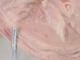 a pink bowl with a face on it on a metal stand