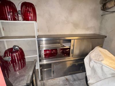 de nombreux vases rouges posés sur les étagères de la cuisine