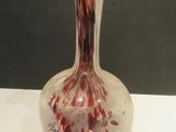 a glass vase with blood on it sitting on a table