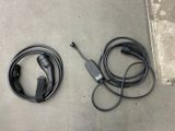 two cables connected to a charger on the ground