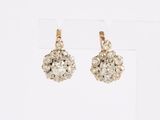 une paire de boucles d'oreilles en or et diamants sur fond blanc