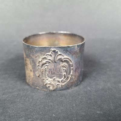 une vieille bague en argent ornée d'un motif, posée sur une table