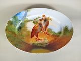 une assiette sur laquelle est représentée une peinture représentant deux oiseaux
