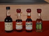 three bottles of liquor are lined up on a red table