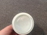 a person holding a white cup in their hand