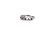 a close up of a silver ring with pink stones on it