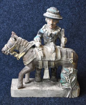 a figurine of a man riding a horse on a blue background