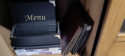 une boîte de menu noire posée sur une pile de livres