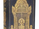 un vieux livre à la couverture dorée et noire posé sur une table