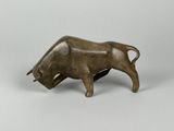 une petite figurine de taureau en bronze sur fond blanc