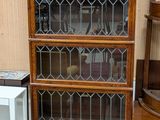 une grande bibliothèque en bois surmontée de portes vitrées