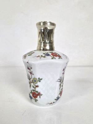 une image représentant une petite bouteille en verre ornée de fleurs