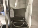 a small bathroom with a sink and a toilet paper dispenser