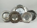 a group of silver plates sitting on a white surface