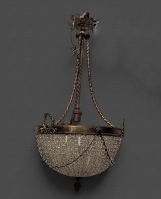 un lustre ancien suspendu au plafond dans une pièce sombre