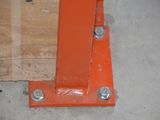 a close up of an orange metal post on the ground