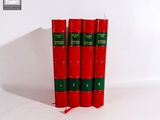 trois livres rouges superposés sur une surface blanche